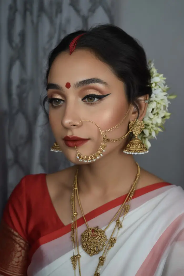 Traditional Bengali Bridal Makeup Look with Gold Jewelry and Red Bindi