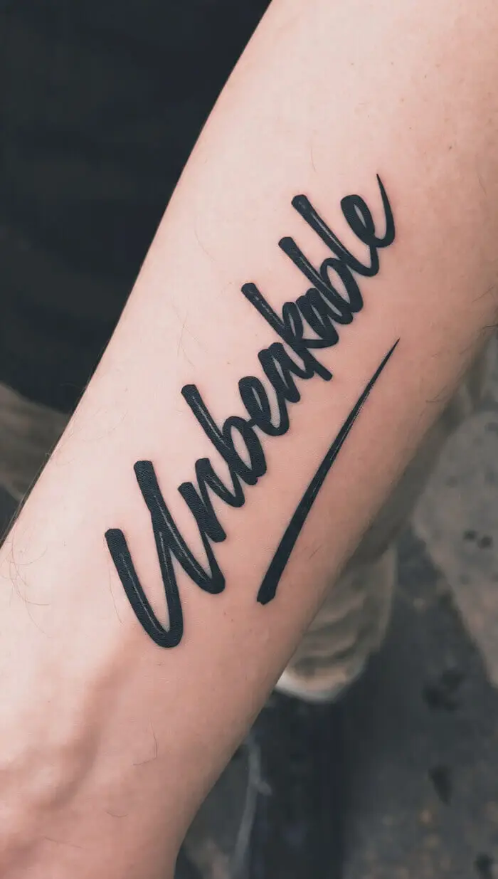 "Unbreakable" Script Tattoo on Forearm – Bold Word Tattoo Design