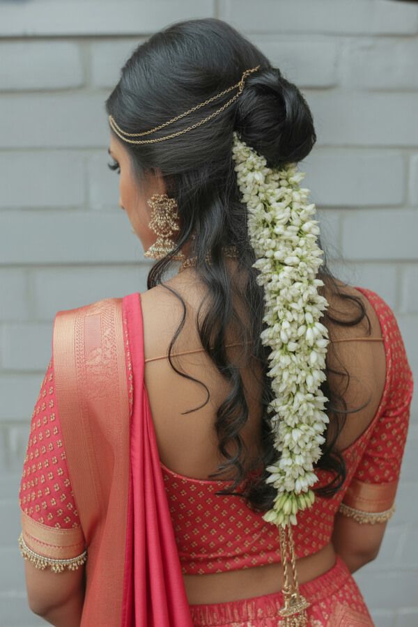 Bridal curly hairstyle with floral bun and gold hair accessories